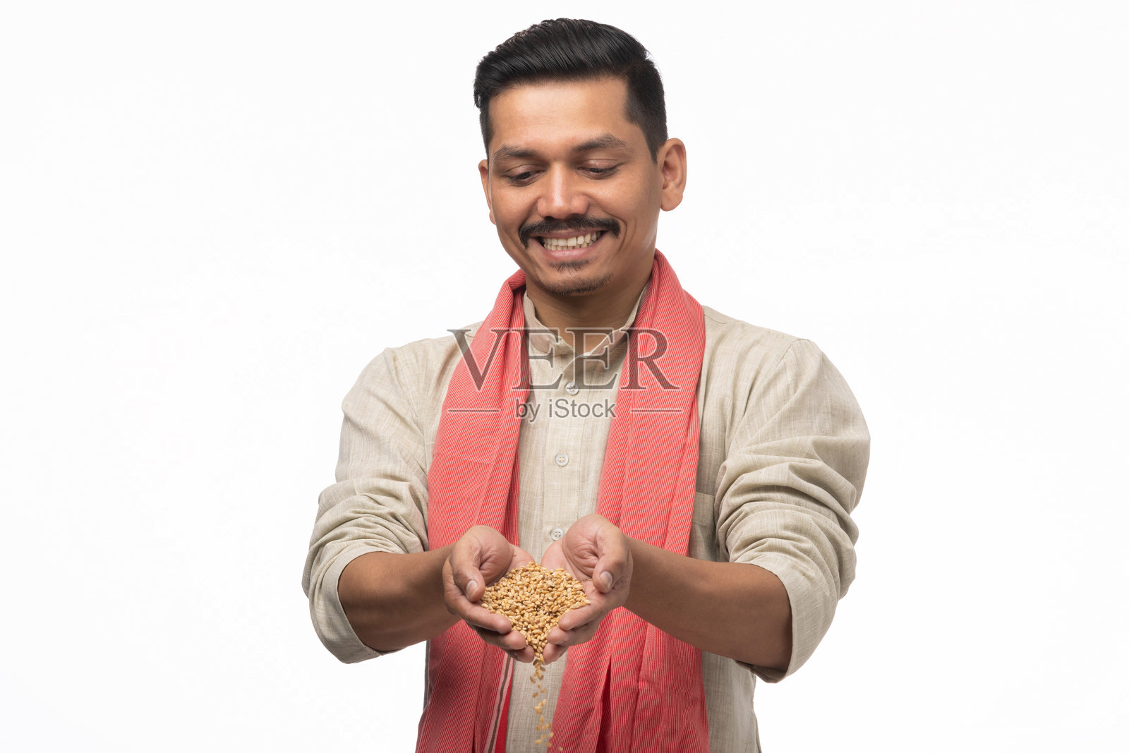 穿着库尔塔的印度年轻农民在白色背景下展示谷物的库存照片照片摄影图片