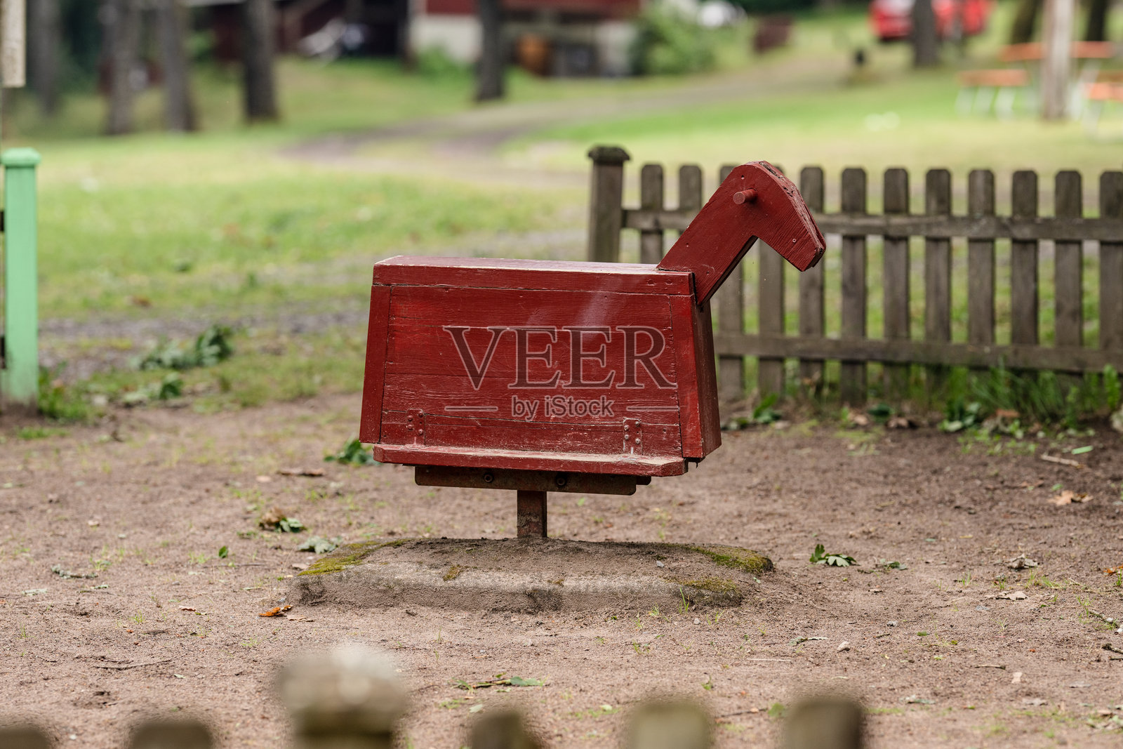 乡村风格的木制秋千马，置于公园环境中。照片摄影图片