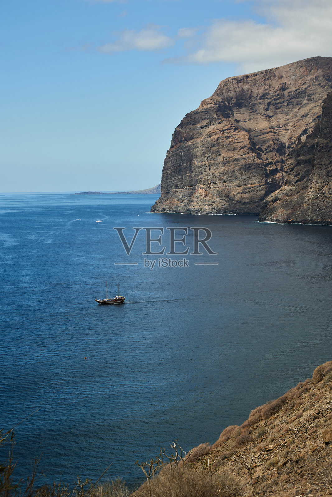 特内里费岛的海岸线，岩石悬崖与水面前景，船只。照片摄影图片