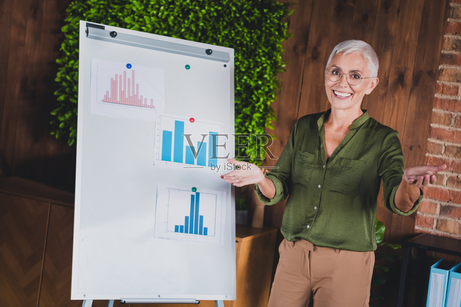 穿着衬衫的快乐女会计师金融助理在室内工作站展示图表照片摄影图片