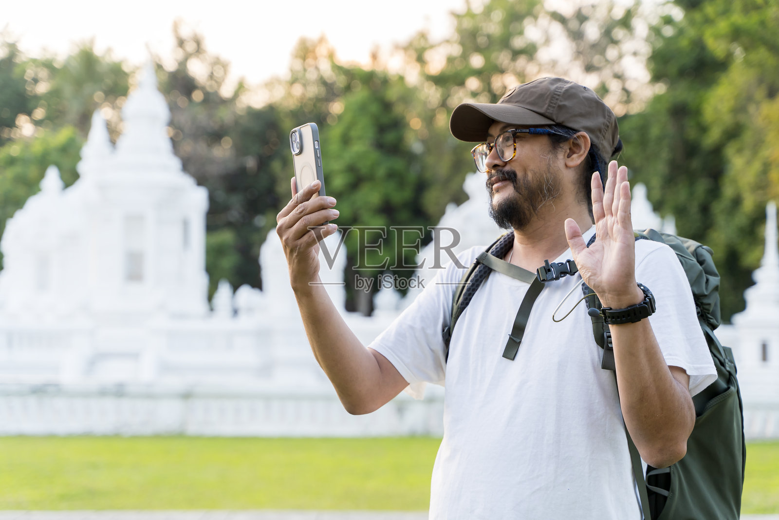快乐的游客在旅行中使用手机进行视频通话。快乐的男性博主，白人男性。照片摄影图片