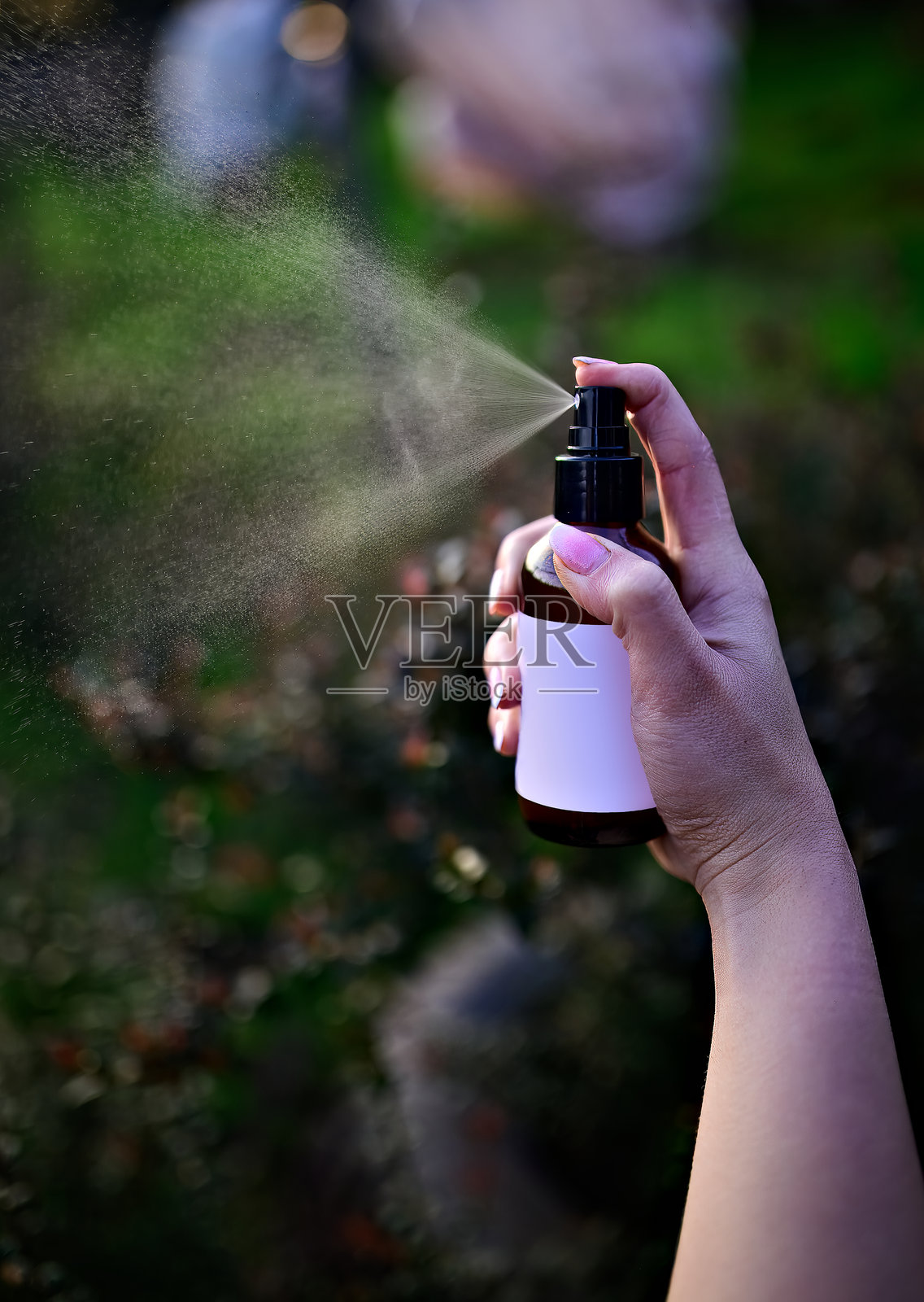 女性手持透明质酸喷雾容器喷洒照片摄影图片