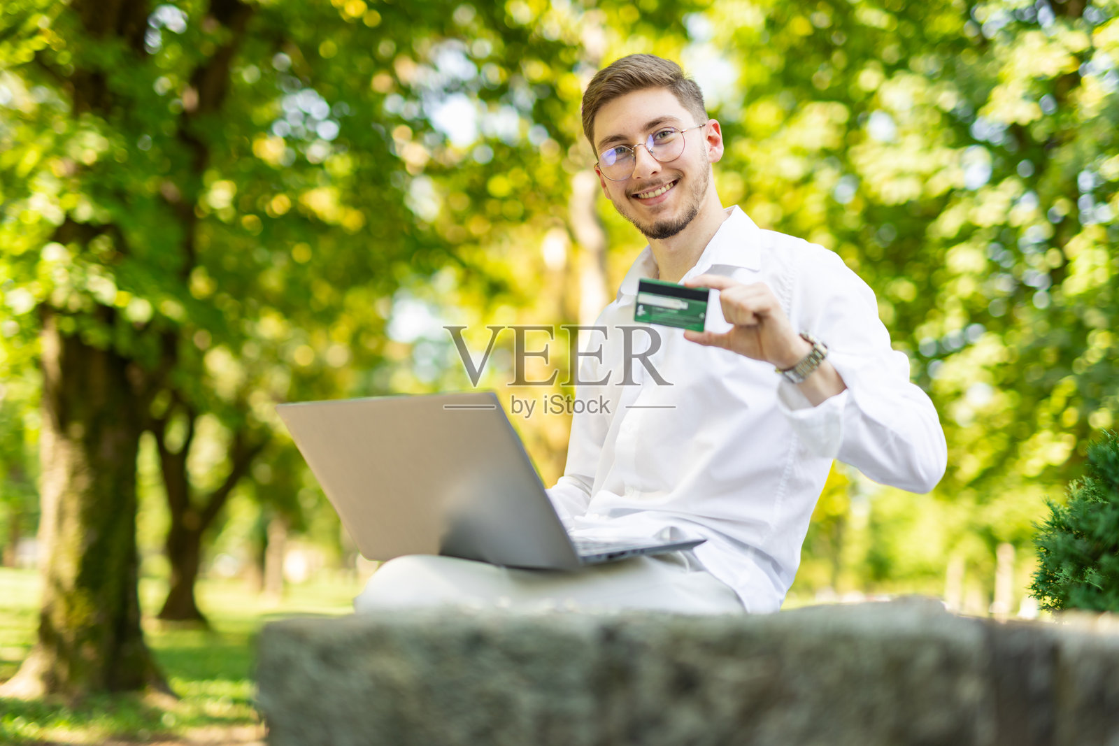 学生在公园使用银行卡进行在线购物照片摄影图片