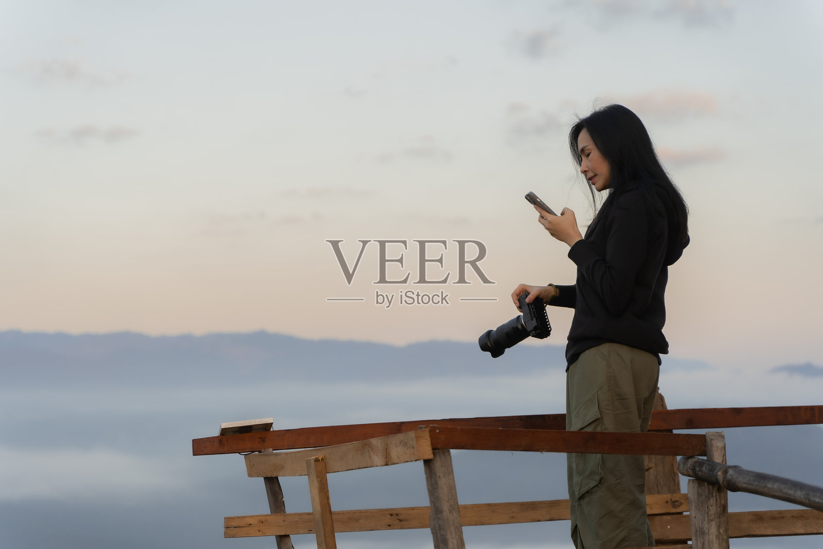 年轻的女游客在清迈省用手机拍摄山景照片摄影图片