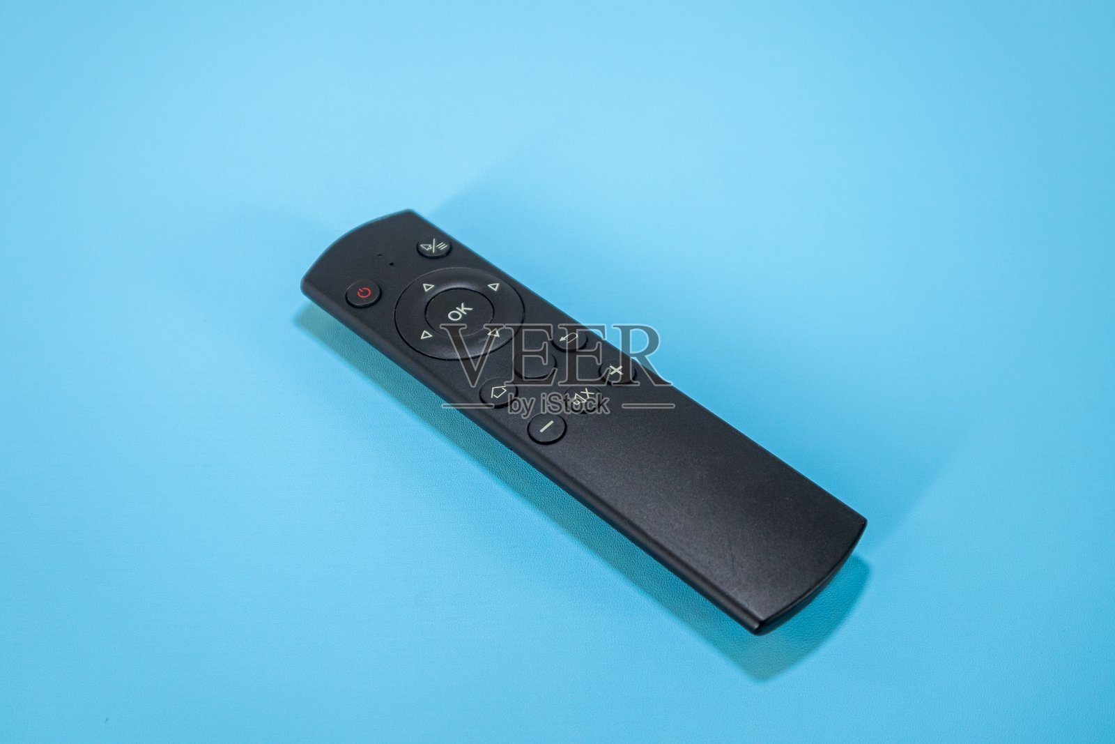 蓝色背景上的黑色遥控器照片摄影图片