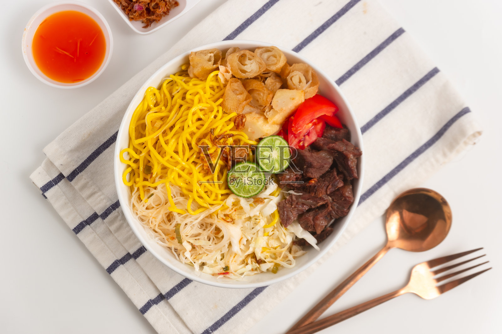 博戈尔索托米。传统的巽他牛肉面汤，配有春卷、卷心菜和番茄。来自印度尼西亚西爪哇的街头美食。照片摄影图片