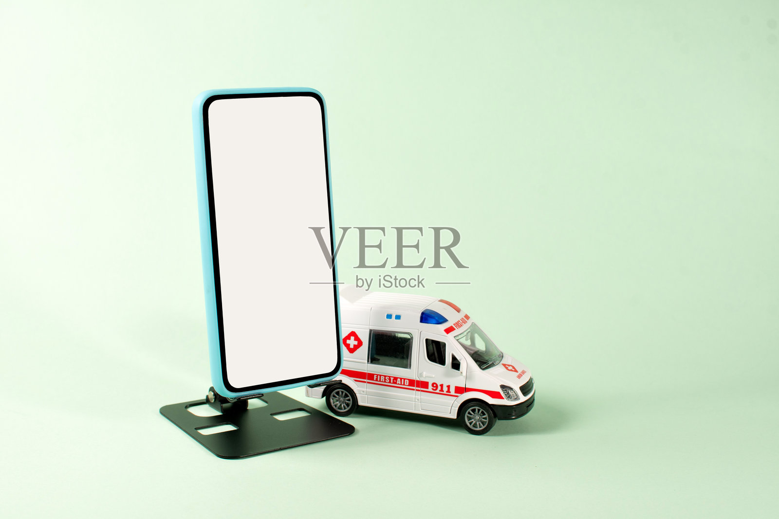 桌子上的玩具救护车和手机，用于紧急应用程序照片摄影图片