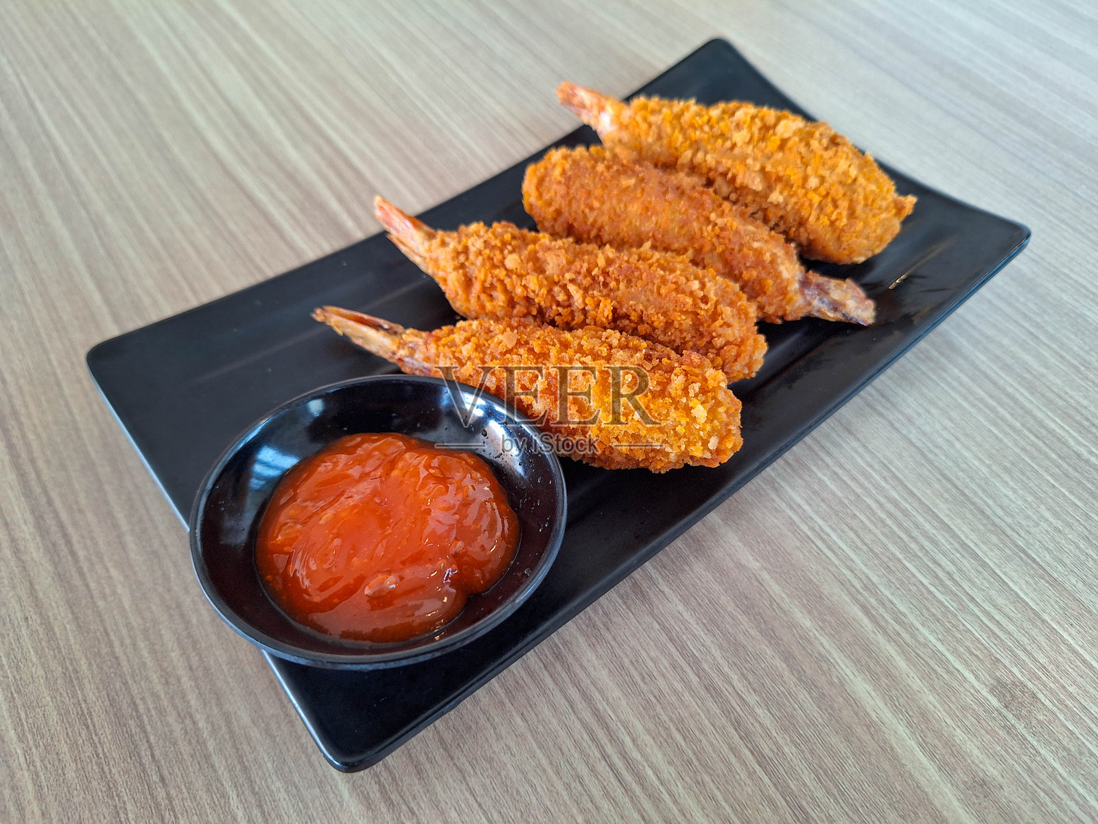 美味的虾天妇罗是裹着面包屑的炸虾，配有辣酱。日本料理菜单。照片摄影图片