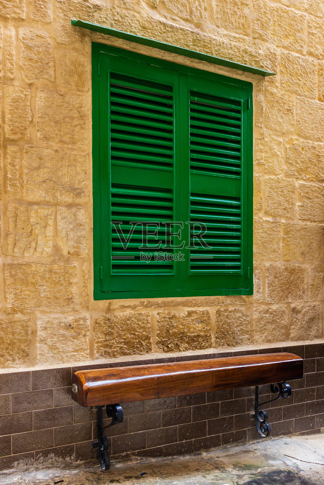 绿色木百叶窗和乡村石墙上的长椅照片摄影图片