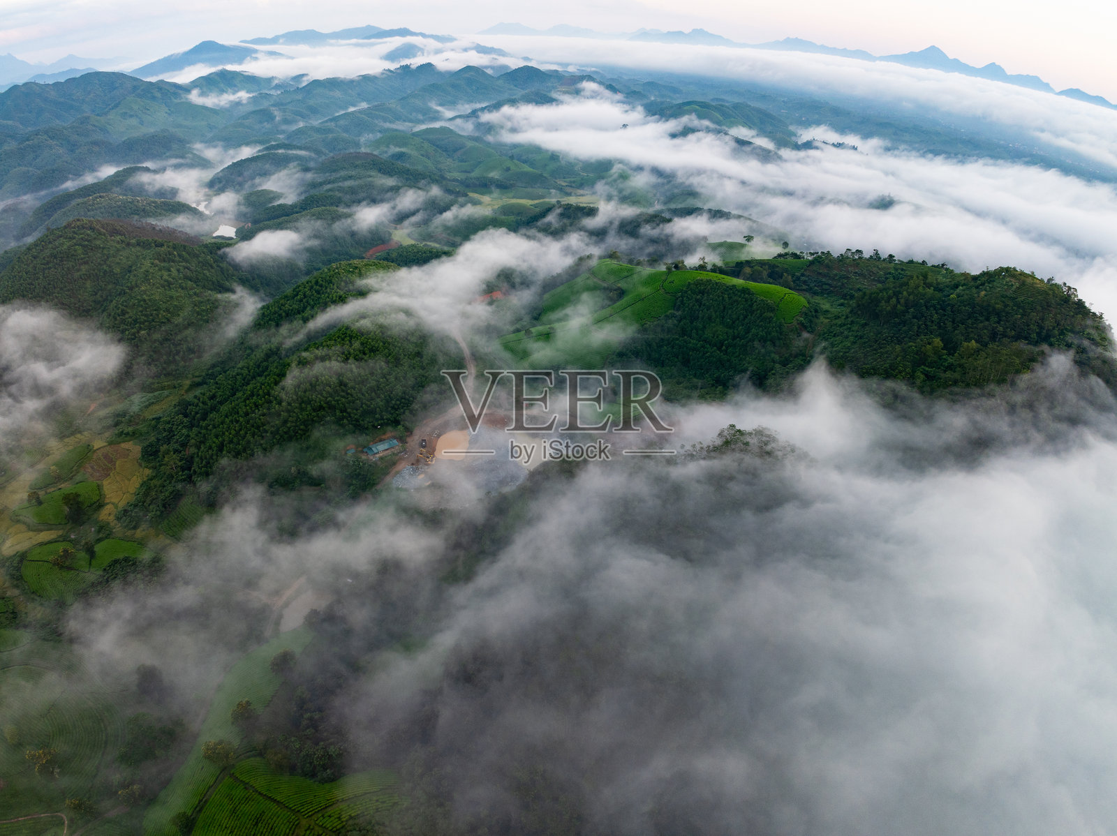 无人机航拍的山脉上空的雾景，日出时的天空，高角度俯瞰越南北部的乡村，广角视图照片摄影图片