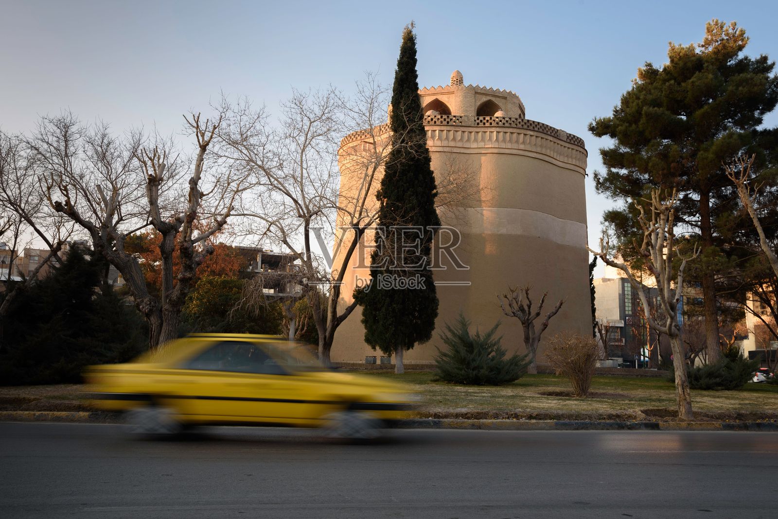 黄色出租车经过伊斯法罕的鸽子塔照片摄影图片