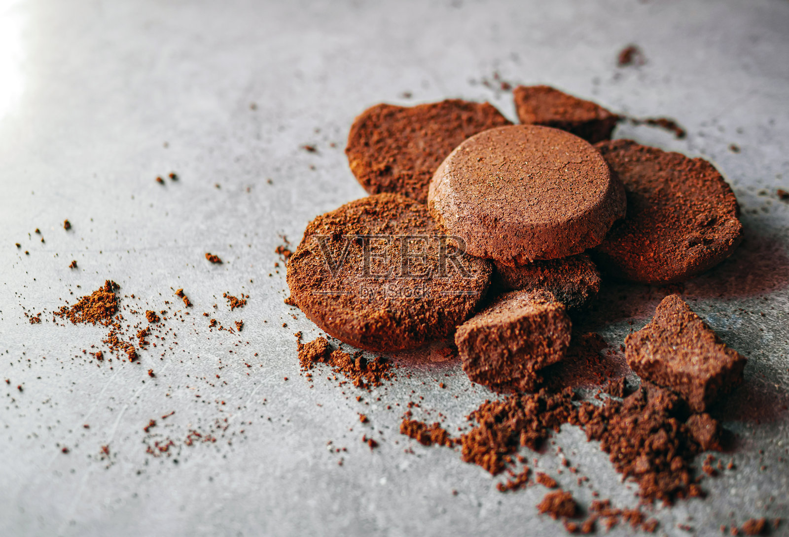 浓缩咖啡机的咖啡渣特写。灰色背景上的咖啡渣。照片摄影图片