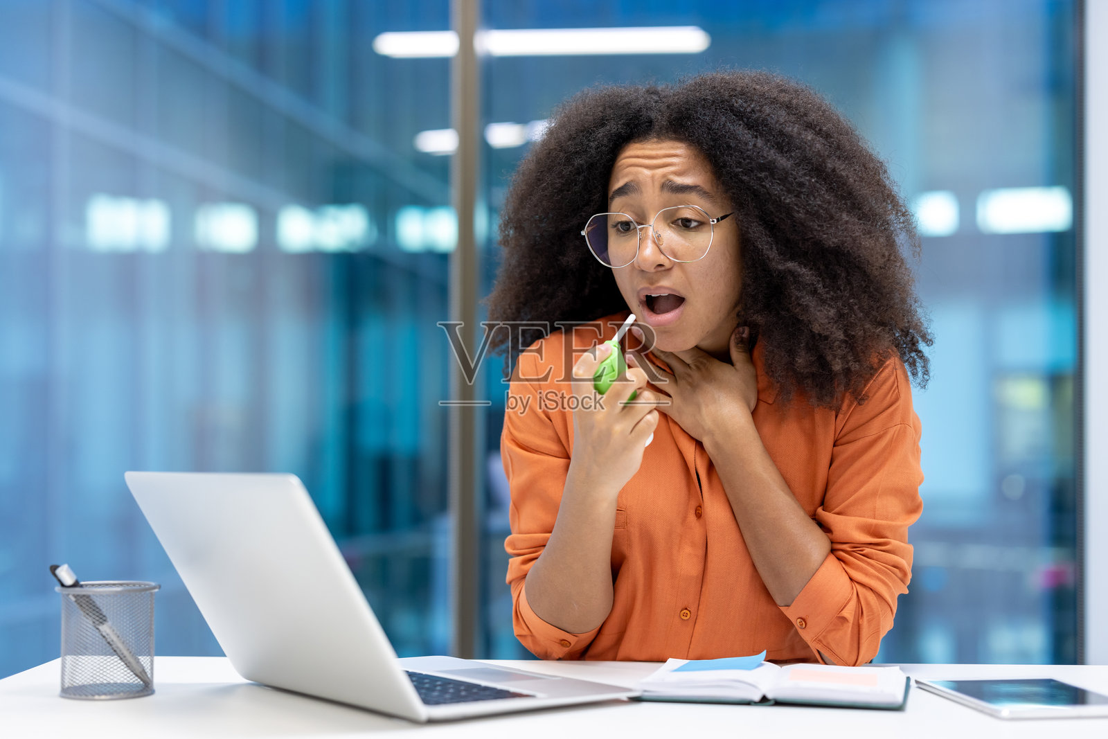 女性在办公室环境中使用药物缓解喉咙不适照片摄影图片