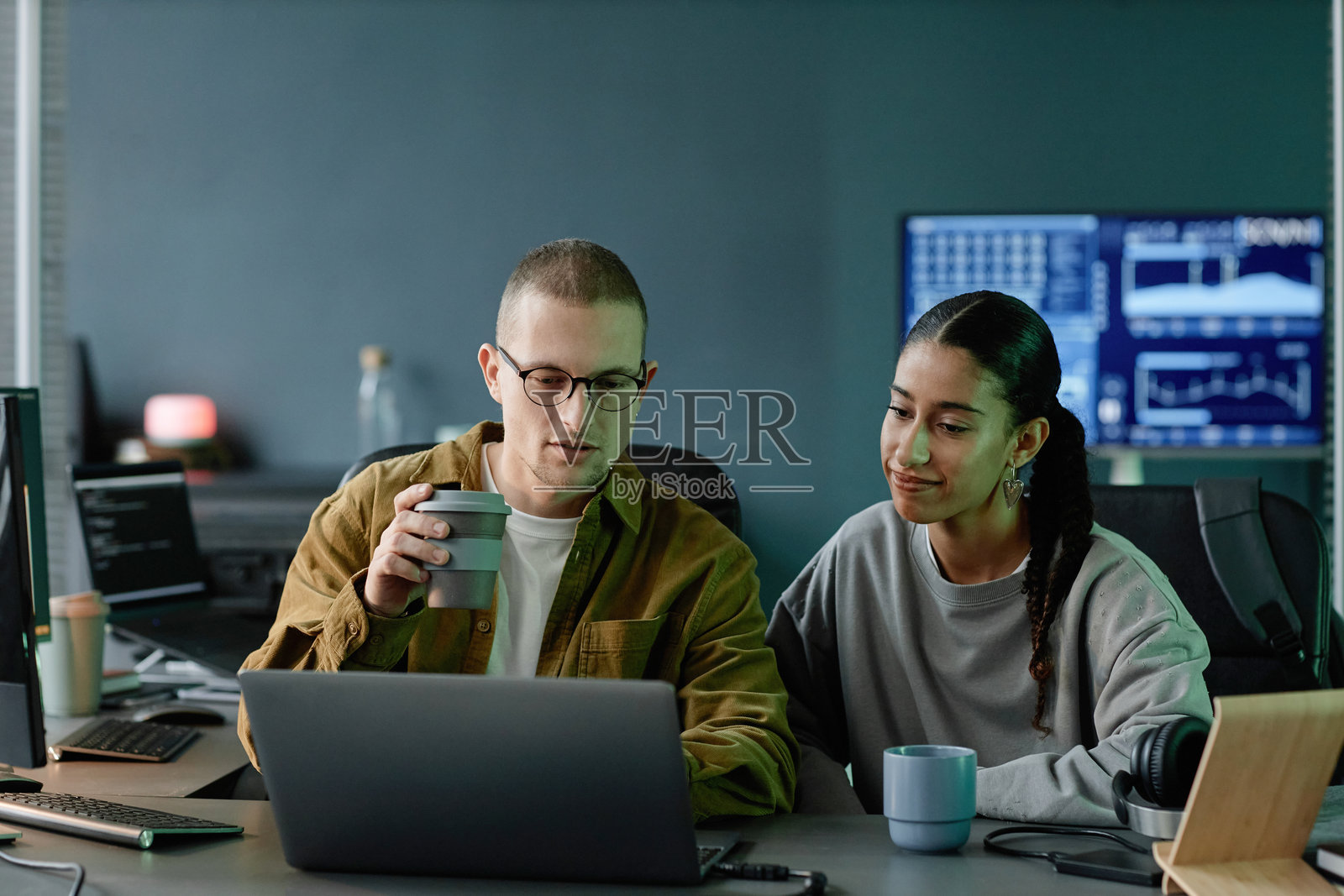 两位积极的程序员在办公室使用笔记本电脑讨论代码调试照片摄影图片