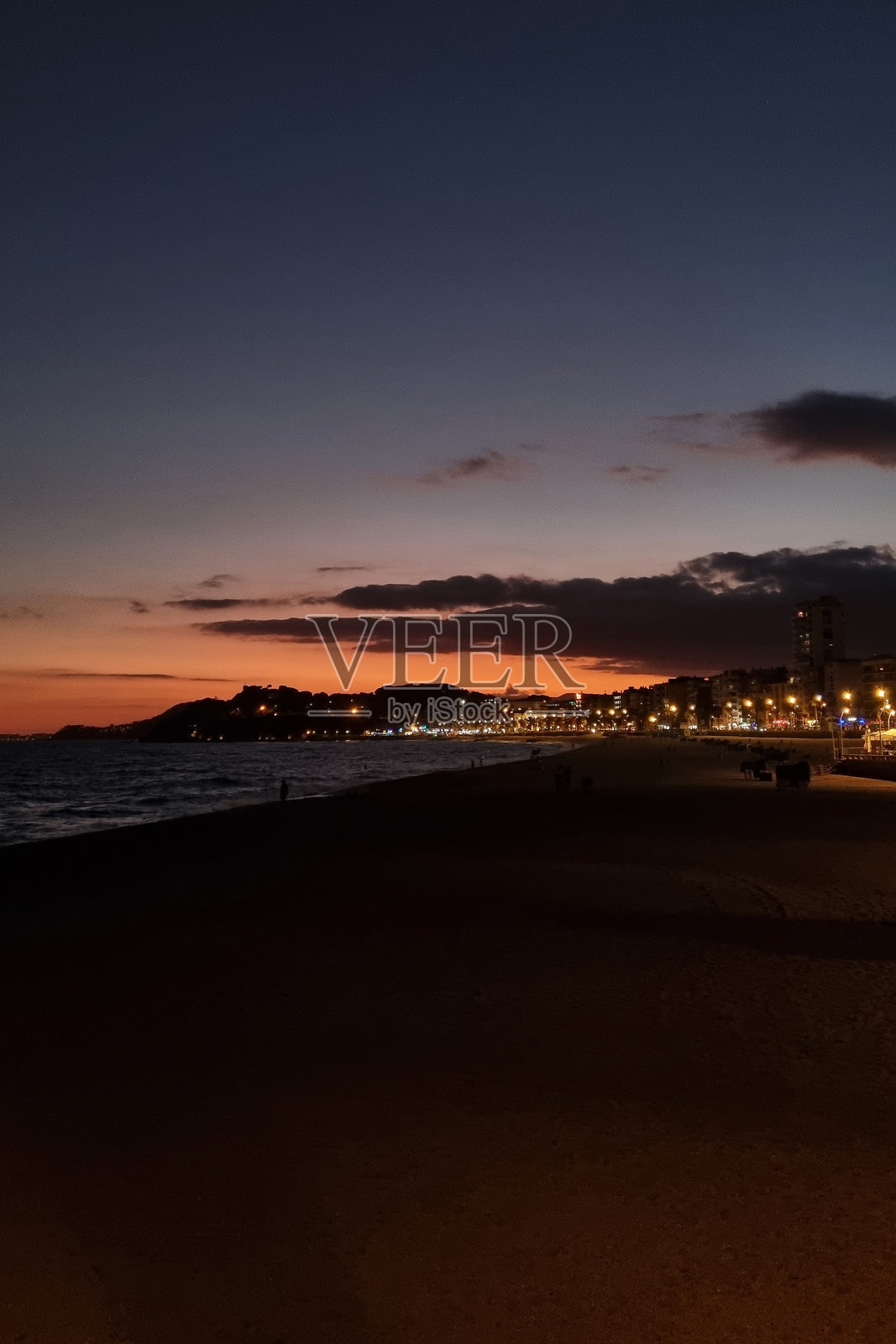 黄昏时的海滨城市景观：城市摄影中宁静的海滩天际线带来晚间的宁静照片摄影图片