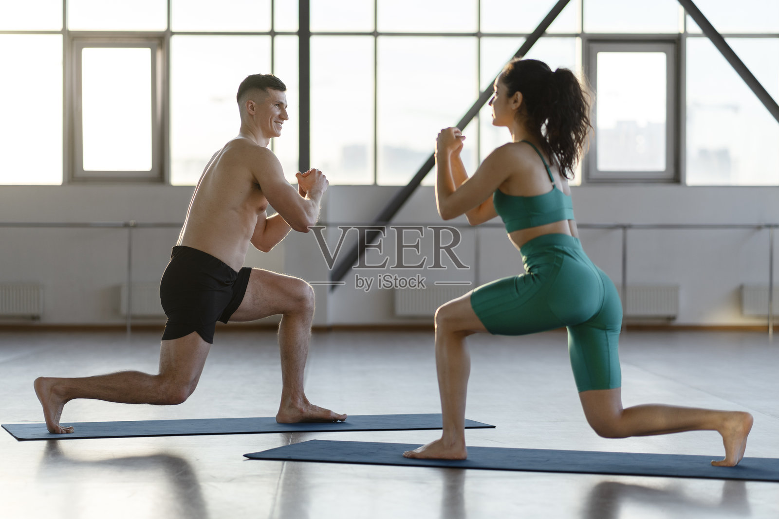 微笑迷人的男女在室内健身馆做健身运动照片摄影图片