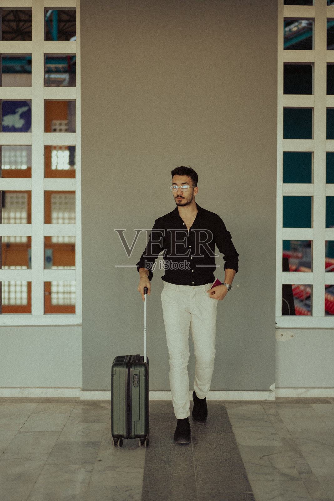 时尚的商人在机场拖着行李箱照片摄影图片
