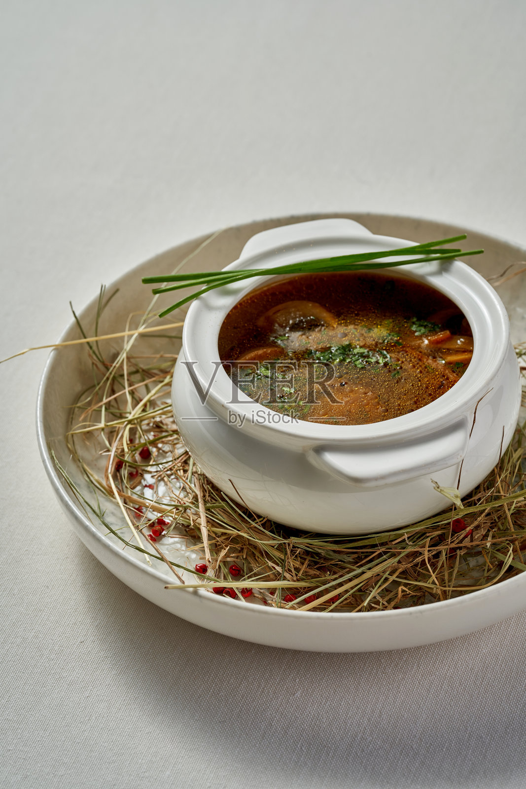 一碗丰盛的喀尔巴阡蘑菇汤，点缀着新鲜香草，盛在一个乡村风格的碗里。照片摄影图片