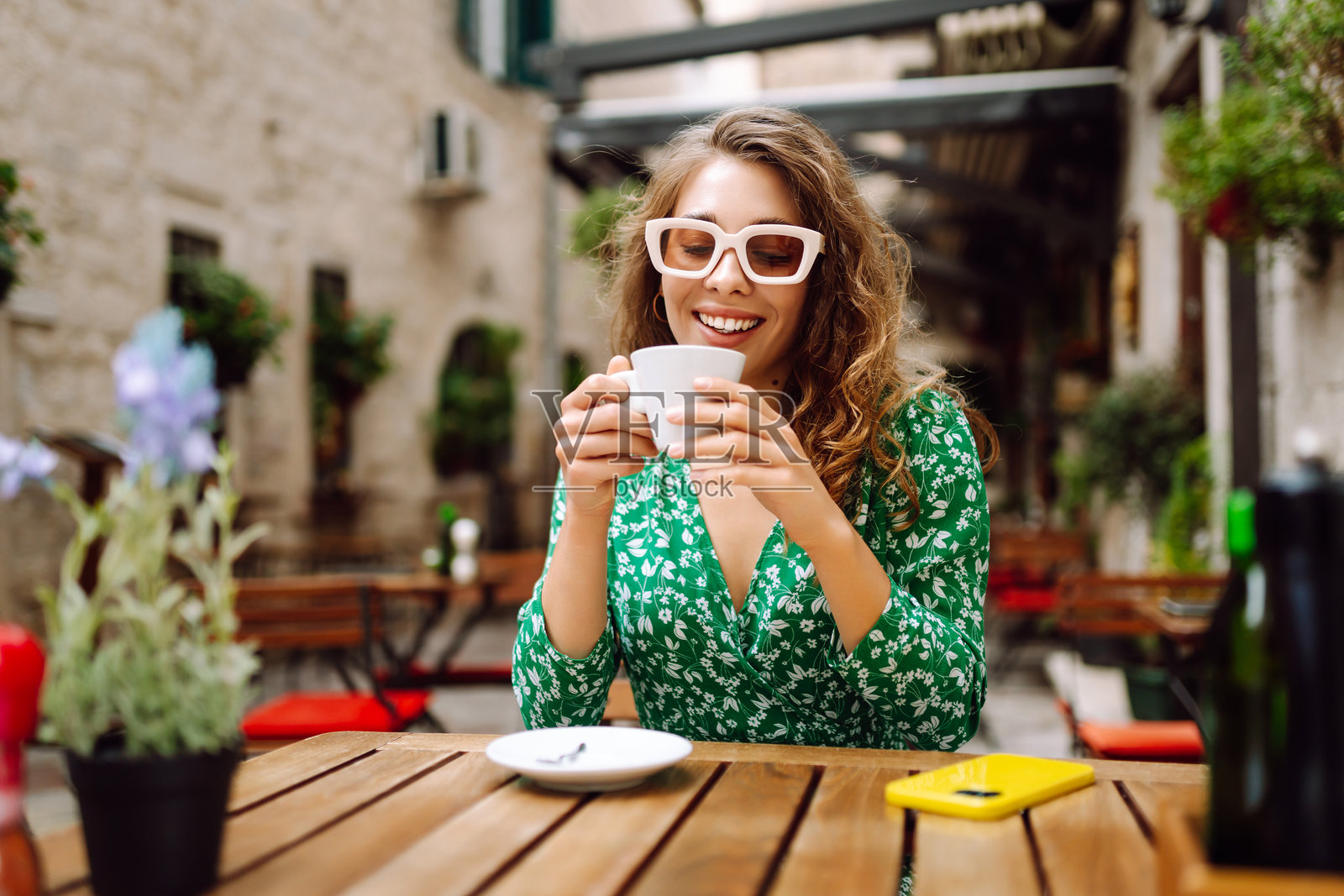 年轻时尚的女性在咖啡馆露台户外享用早餐和咖啡。照片摄影图片