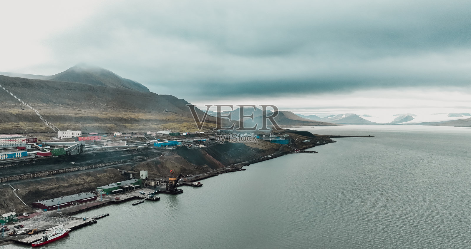 巴伦支堡，斯瓦尔巴群岛，展示了沿海色彩斑斓的建筑和多云的天空照片摄影图片