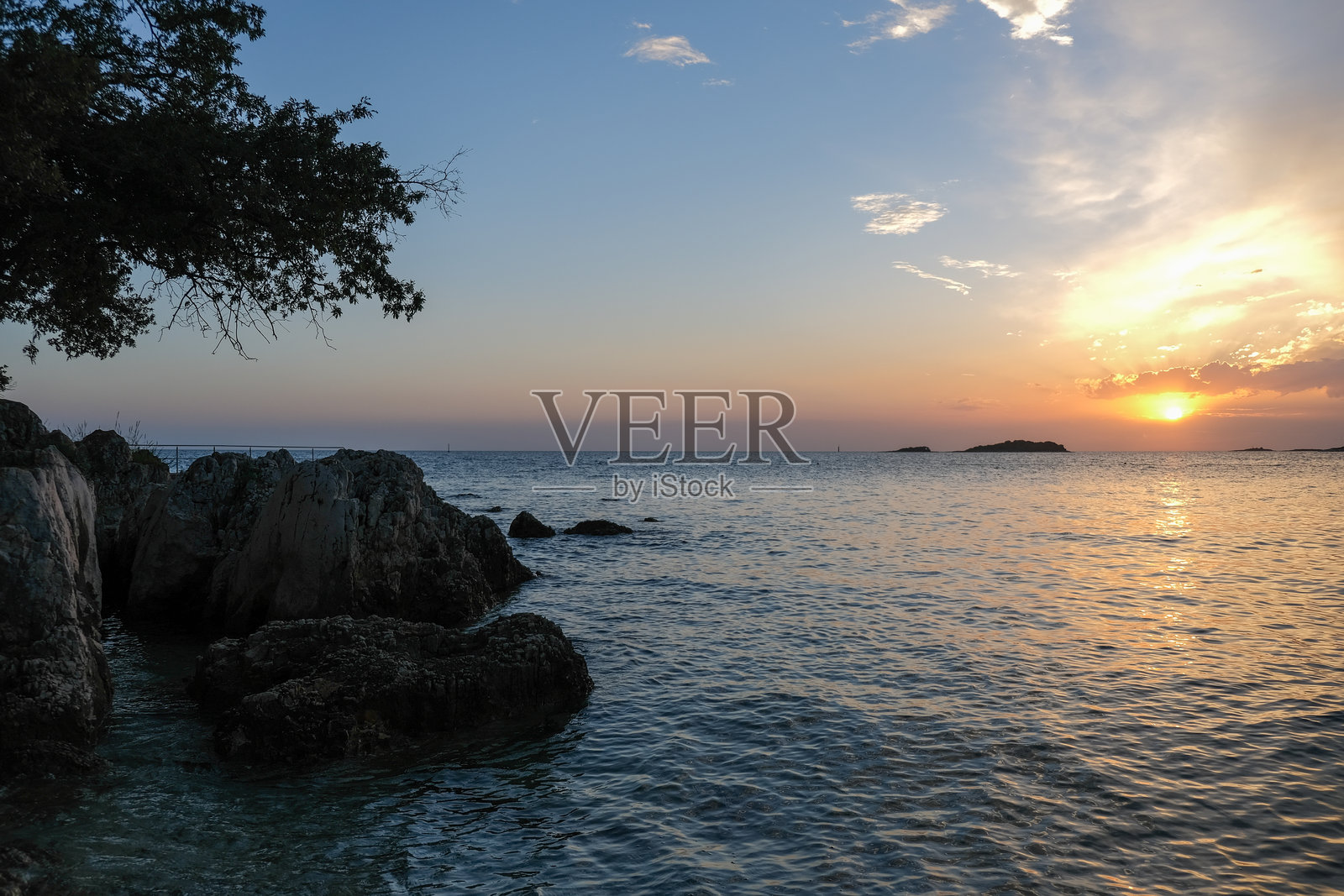 海上壮丽的日落与岩石海岸线照片摄影图片