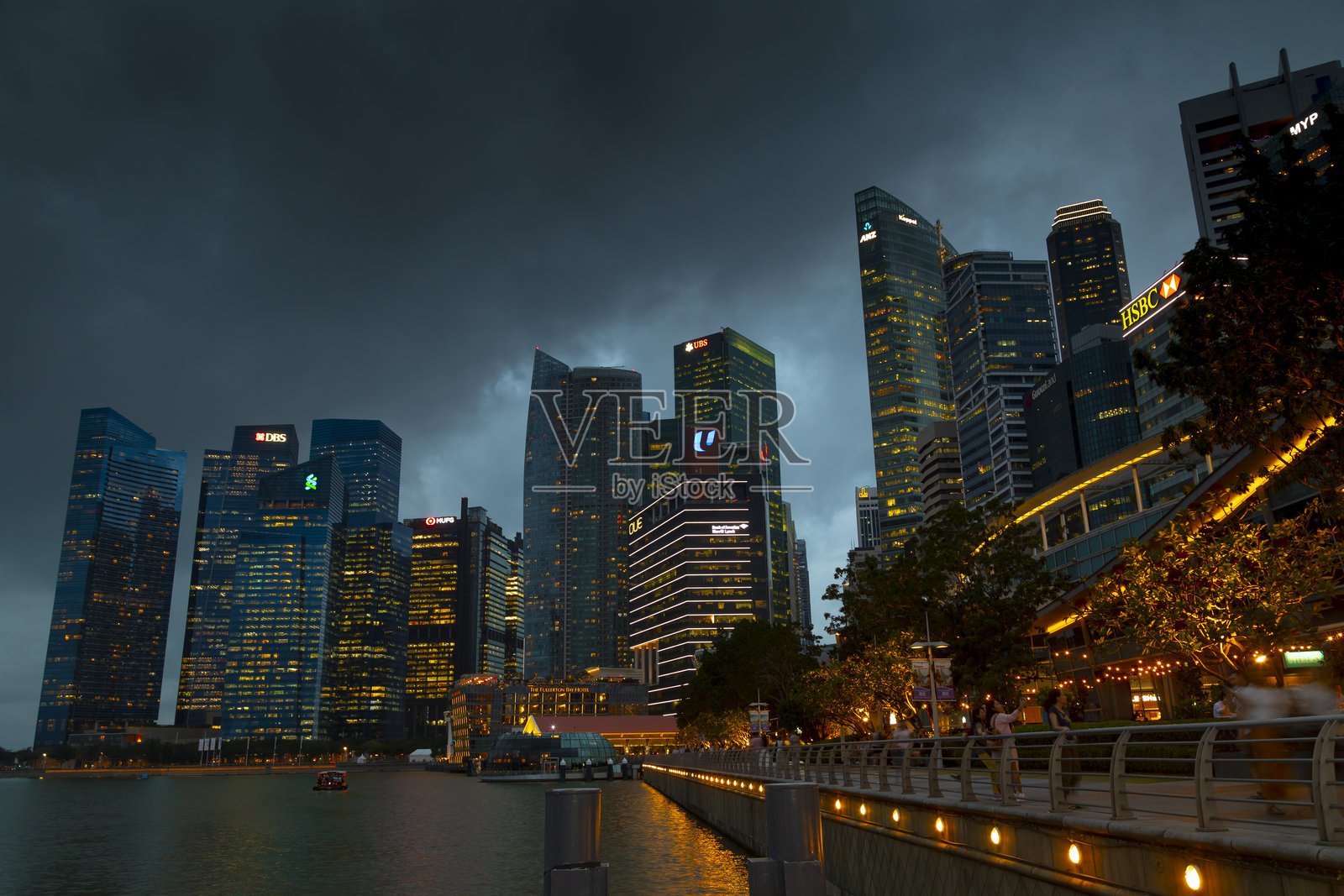 新加坡 - 2019年10月22日：从滨海艺术中心地区俯瞰新加坡天际线及其灯火辉煌的摩天大楼，日落时分，乌云密布。照片摄影图片