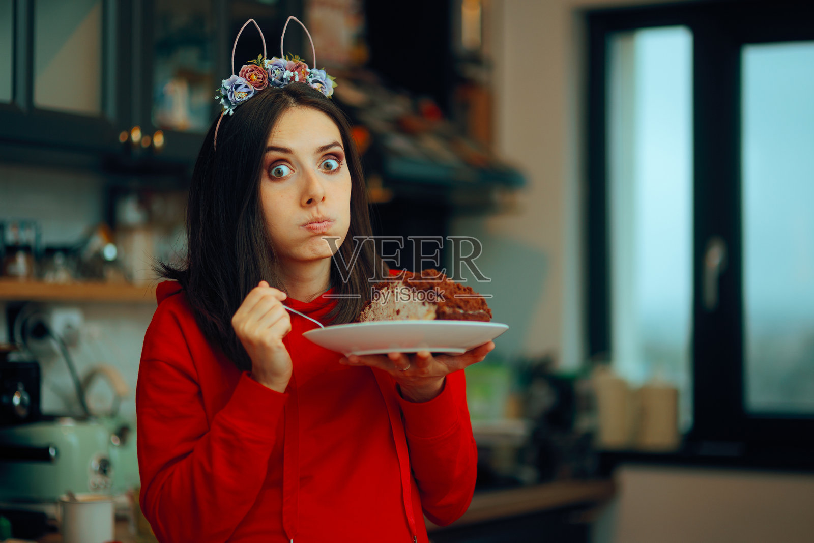 搞笑的女人戴着复活节头带吃可可蛋糕照片摄影图片