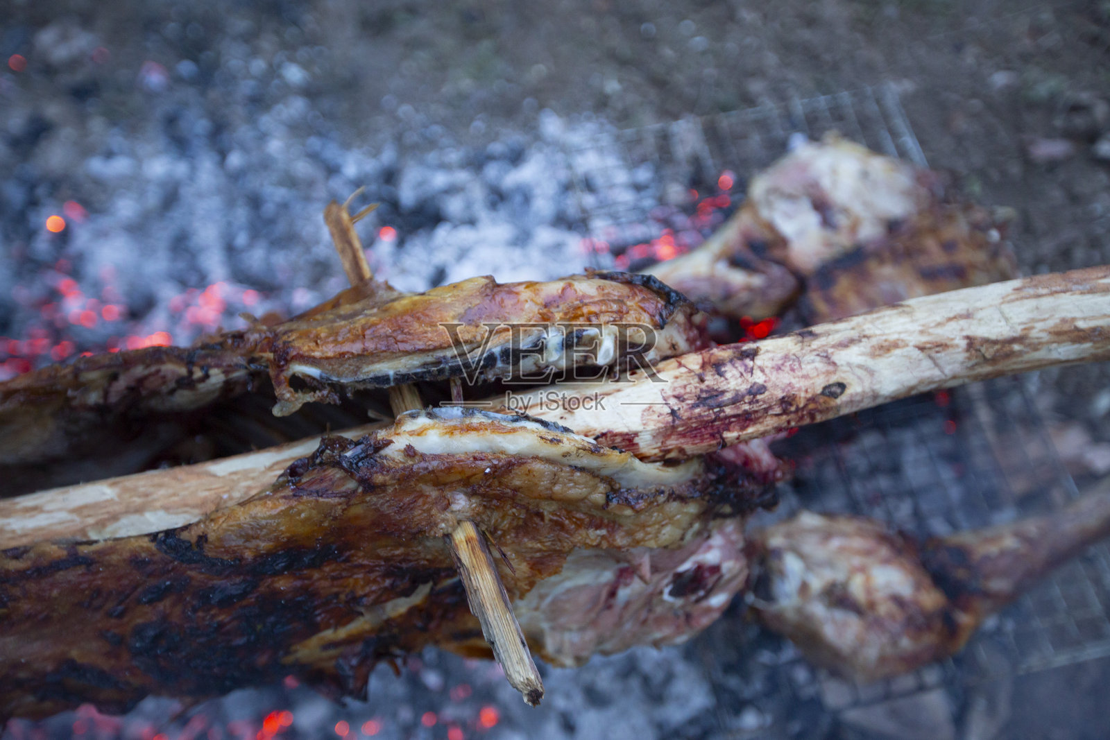 在篝火上烹饪整只羊肉照片摄影图片