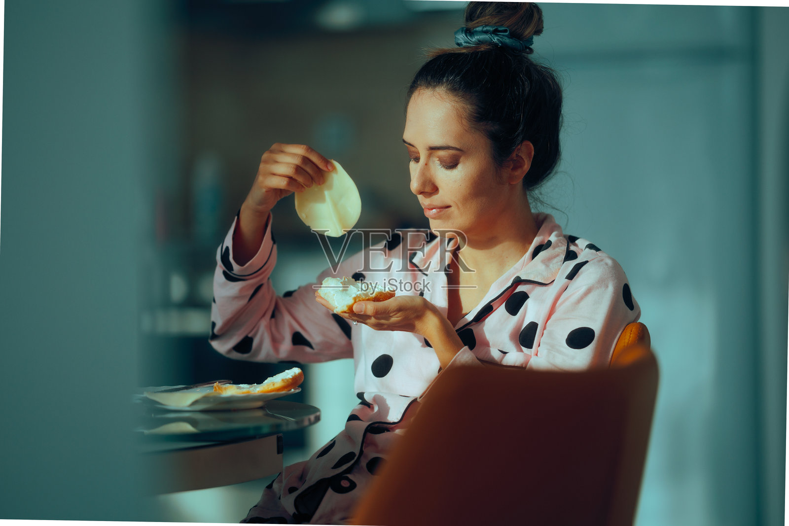 女人在早晨的早餐三明治中加入火腿照片摄影图片