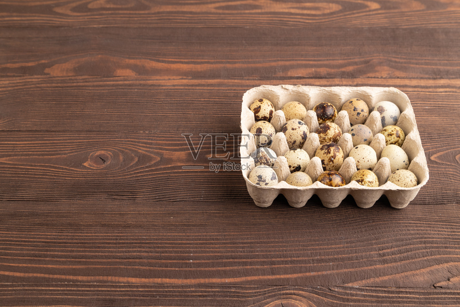 一堆生鹌鹑蛋放在棕色木头上。侧面视图，有空白空间。照片摄影图片
