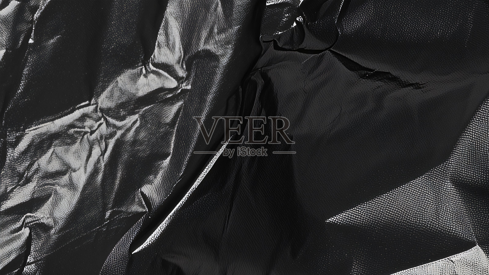 黑色透明塑料薄膜纹理叠加背景。用于海报设计和照片叠加效果的逼真塑料。皱纹塑料表面图案，适用于图形设计素材和元素模型。照片摄影图片