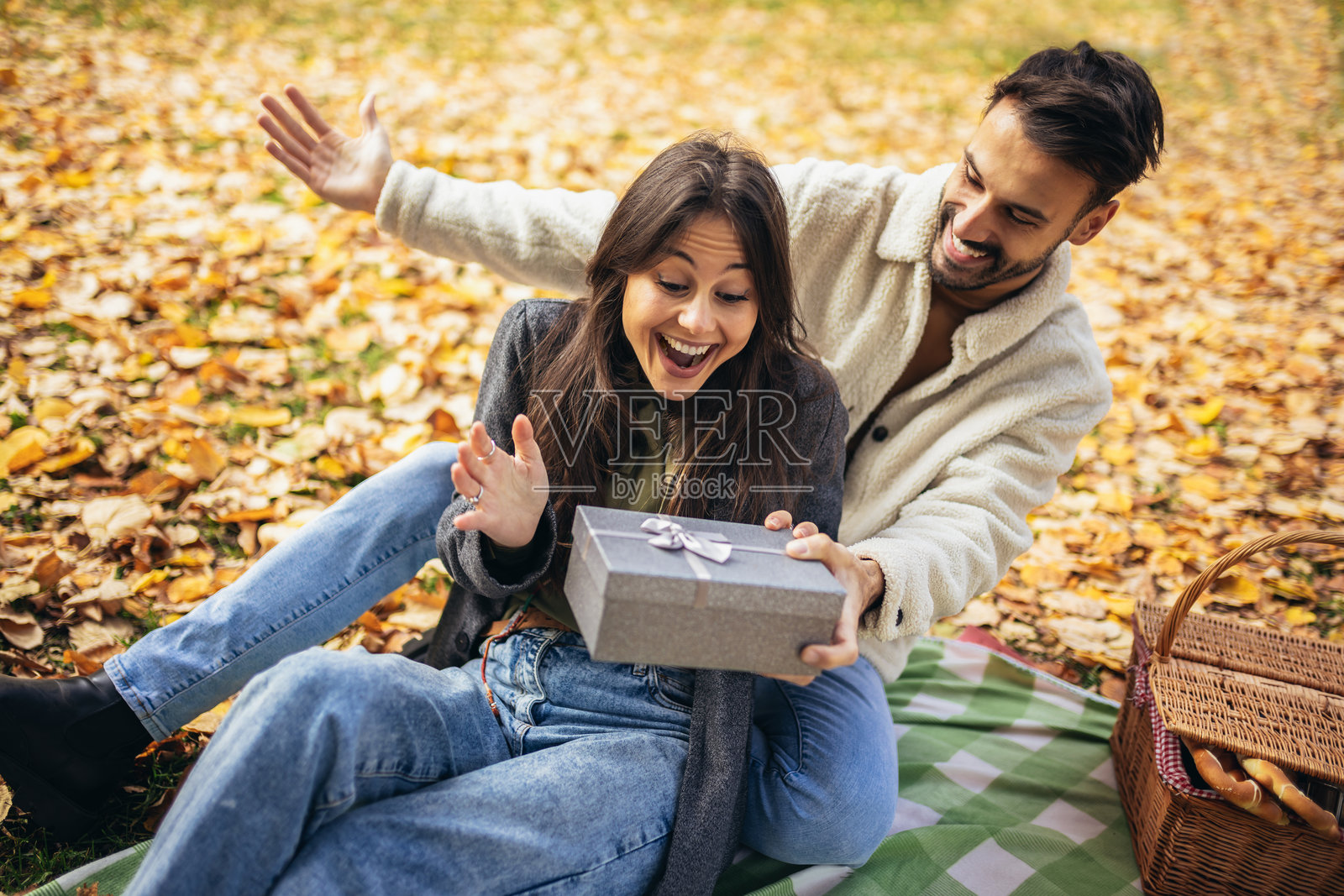 男朋友在情人节给女朋友准备了一份惊喜礼物，带她去野餐。照片摄影图片