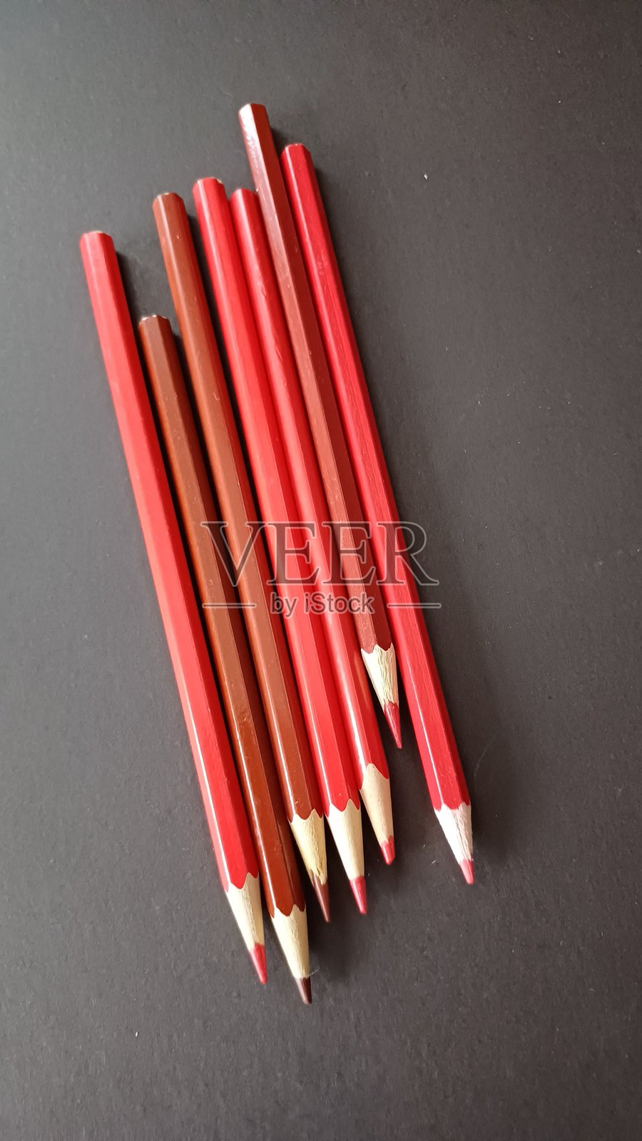 黑色背景上的红色蜡笔。照片摄影图片