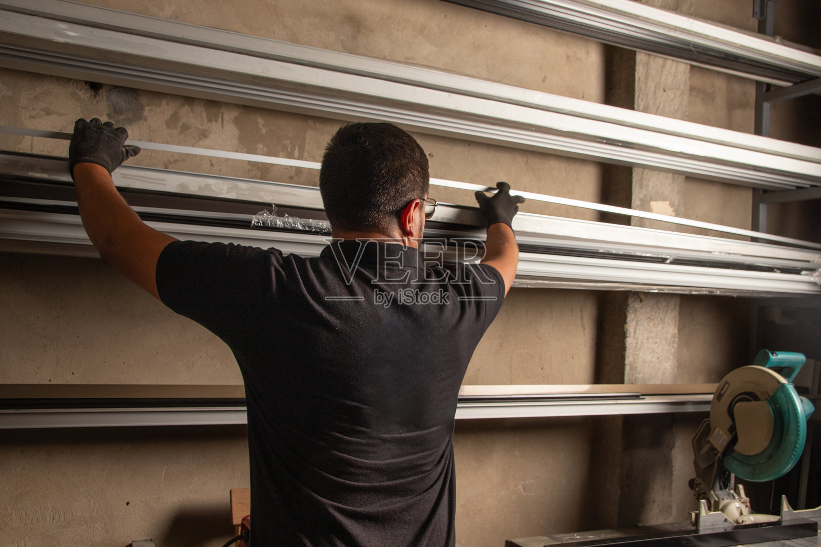 工人正在将金属管和杆整理在壁挂式支架上照片摄影图片