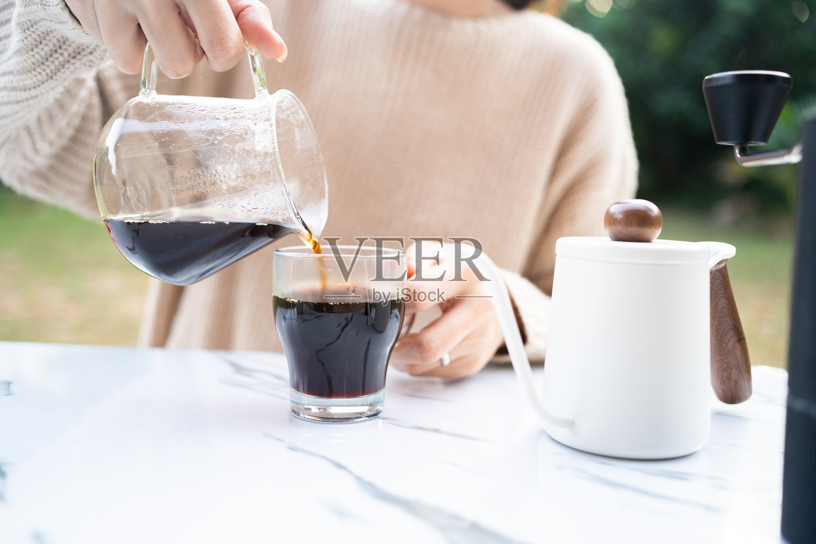 亚洲女性在露营地制作手工滴漏咖啡。照片摄影图片