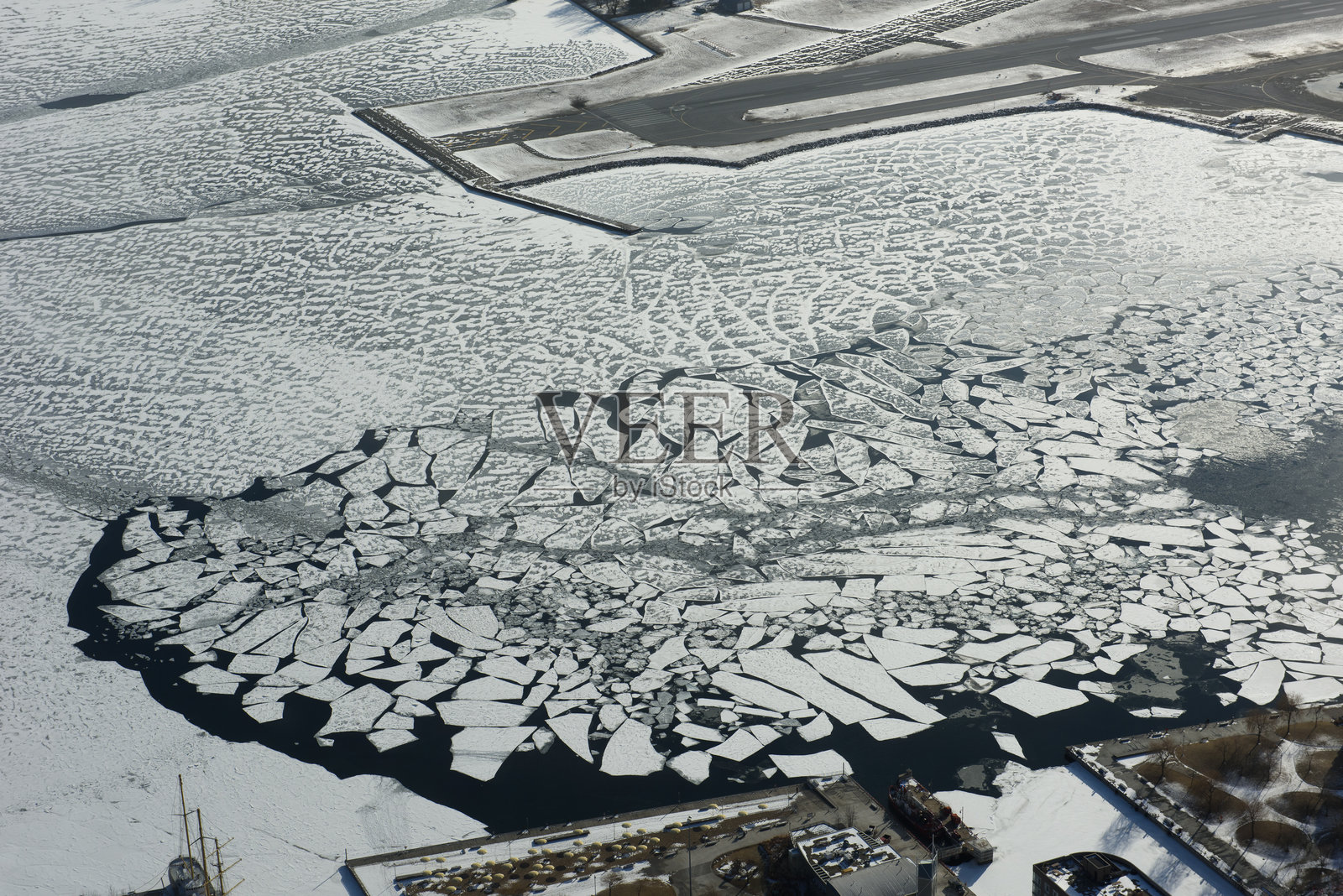 从空中俯瞰加拿大多伦多市沿湖岸线的冰冻雪覆盖的安大略湖。照片摄影图片