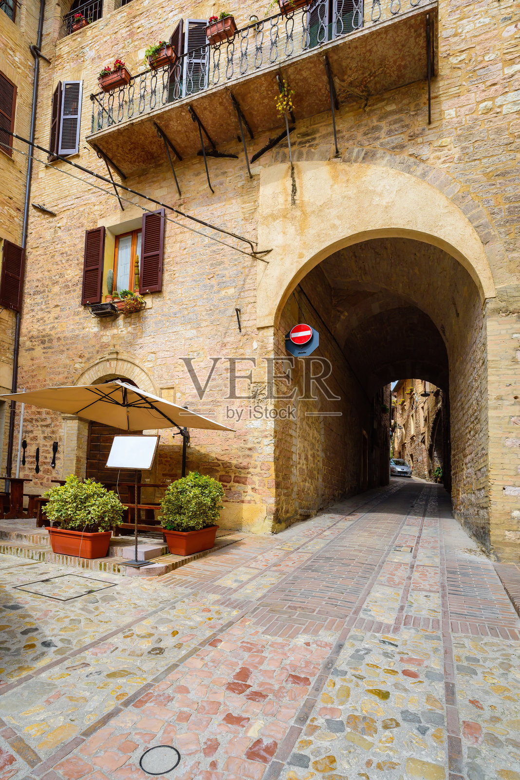 斯派洛大街上的小纪念品商店。狭窄的步行街和装饰着鲜花的斯佩洛庭院。意大利的小镇之旅照片摄影图片