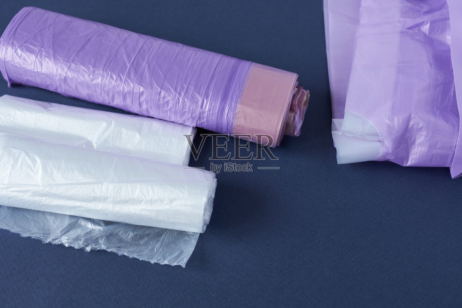 蓝色背景的塑料和聚乙烯垃圾袋卷照片摄影图片