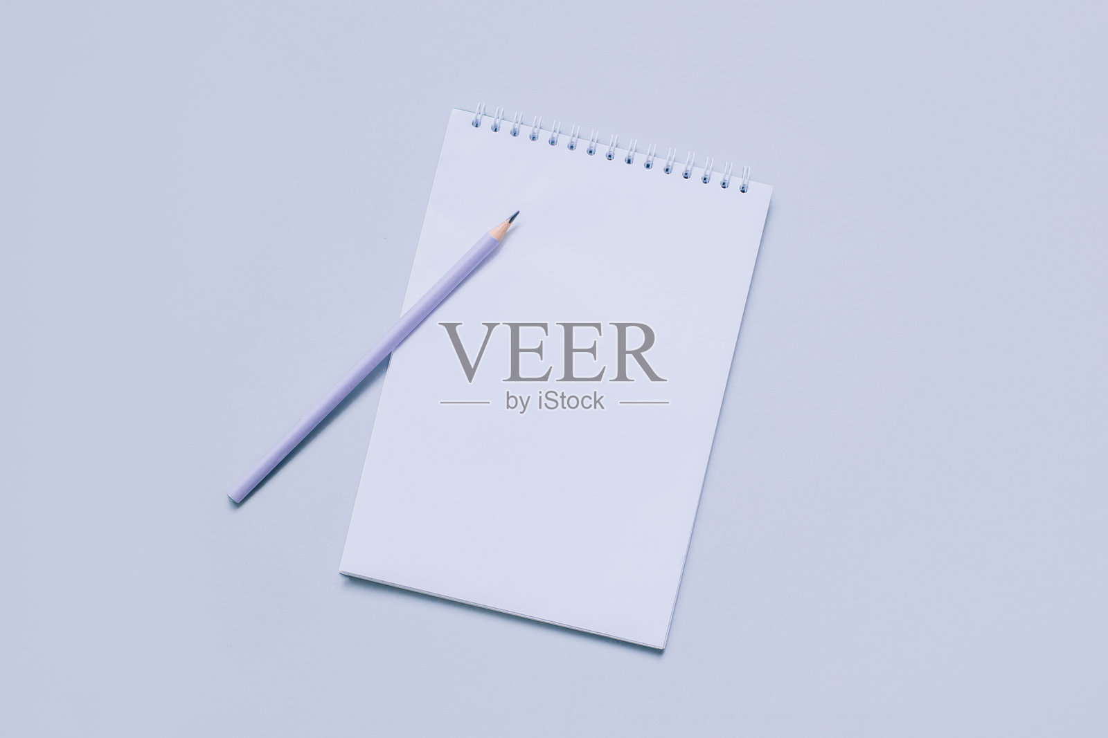 笔记本与空白页和铅笔在浅紫色的背景。照片摄影图片