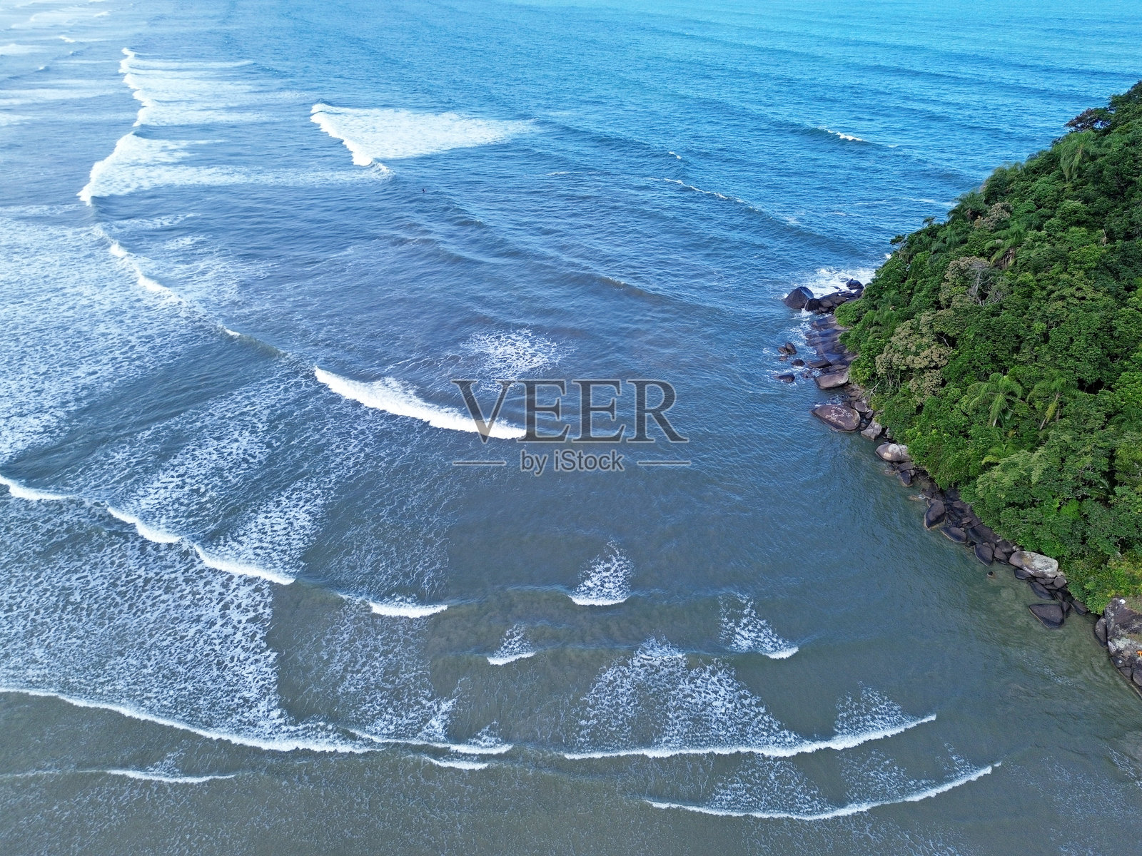 蓝色的海水和波浪环绕着一个岛屿照片摄影图片