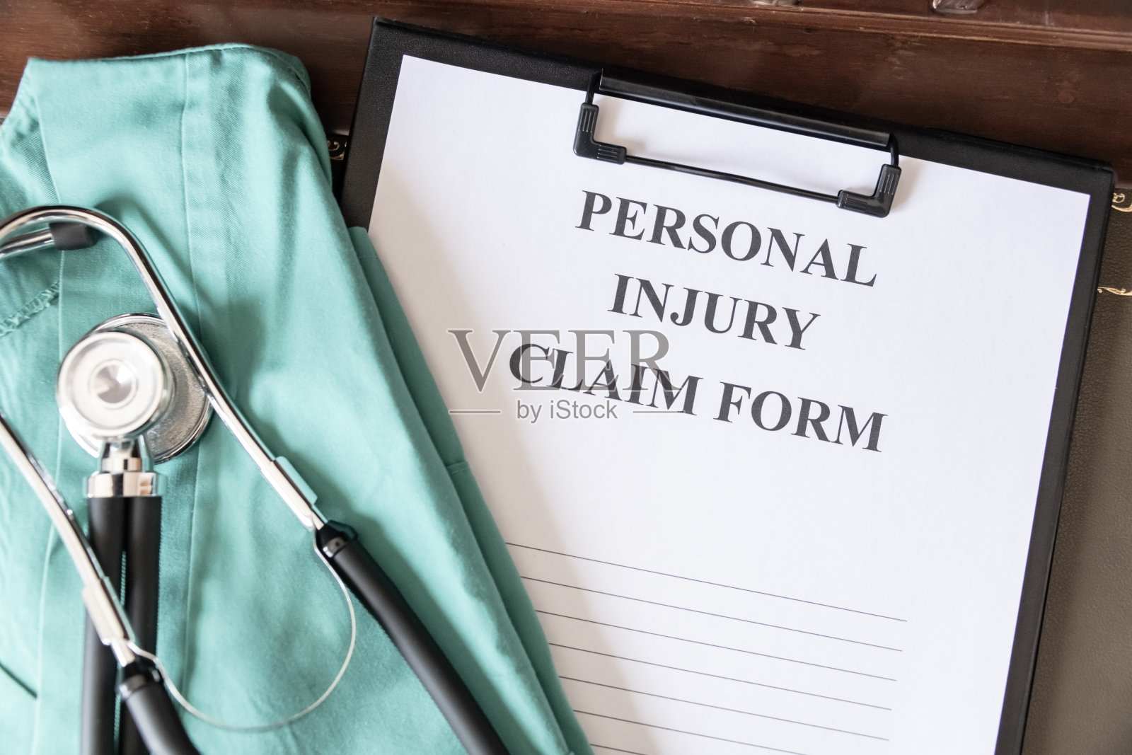 写在剪贴板上的人身伤害索赔表格，附有听诊器和医疗擦洗布，表明与健康有关的法律诉讼。照片摄影图片