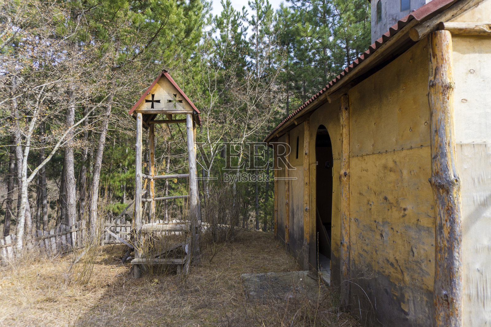 森林里的木制教堂和钟楼。木栅栏，针叶树，干草。秋天的颜色照片摄影图片
