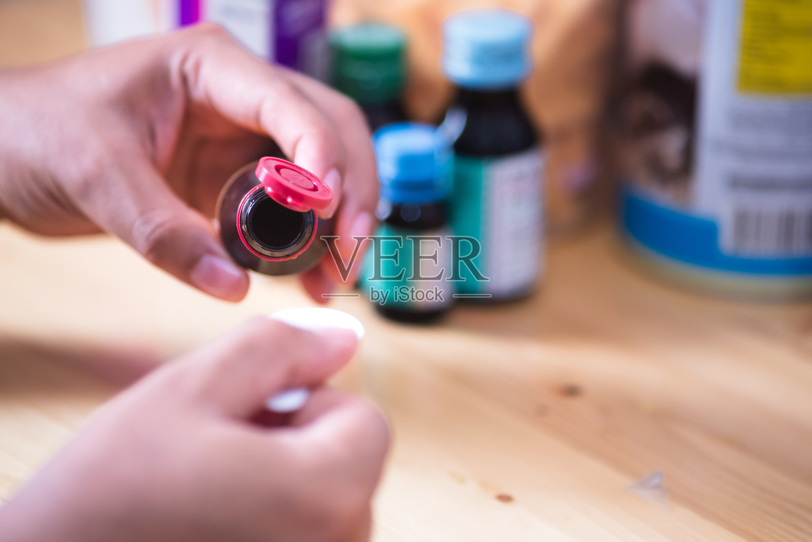 亚洲男子把止咳糖浆倒进勺子里喝。医疗、药学和保健理念照片摄影图片