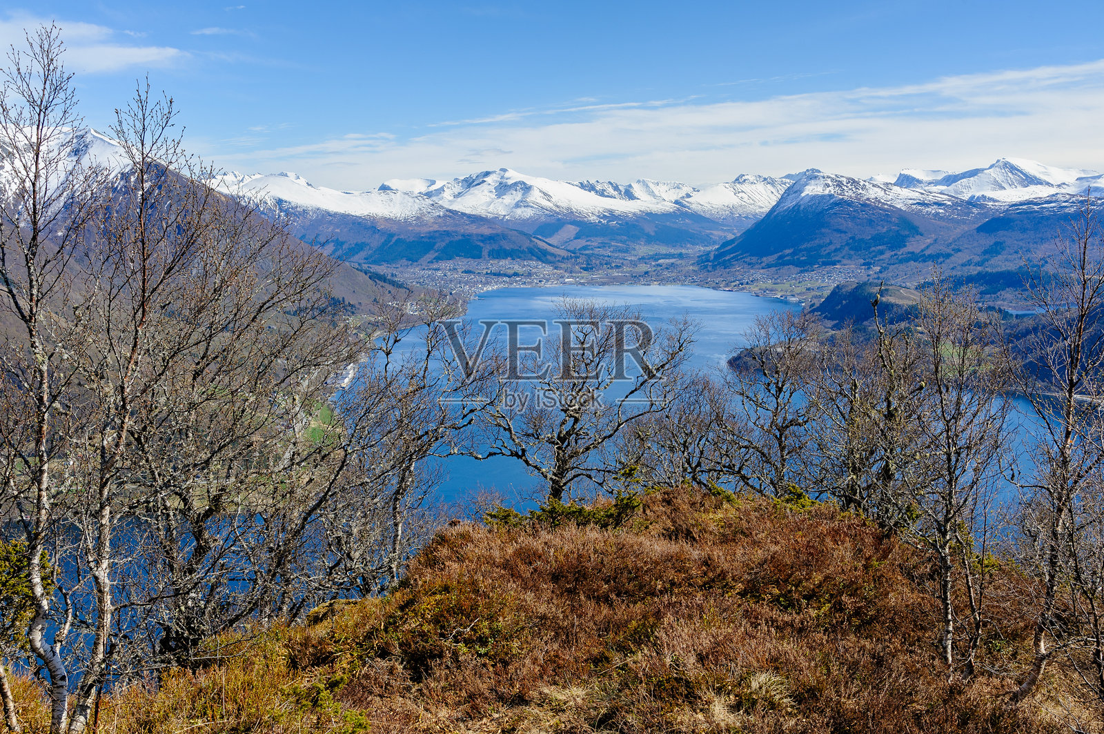 在阳光明媚的日子里，雄伟的山景包括宁静的峡湾和郁郁葱葱的森林照片摄影图片