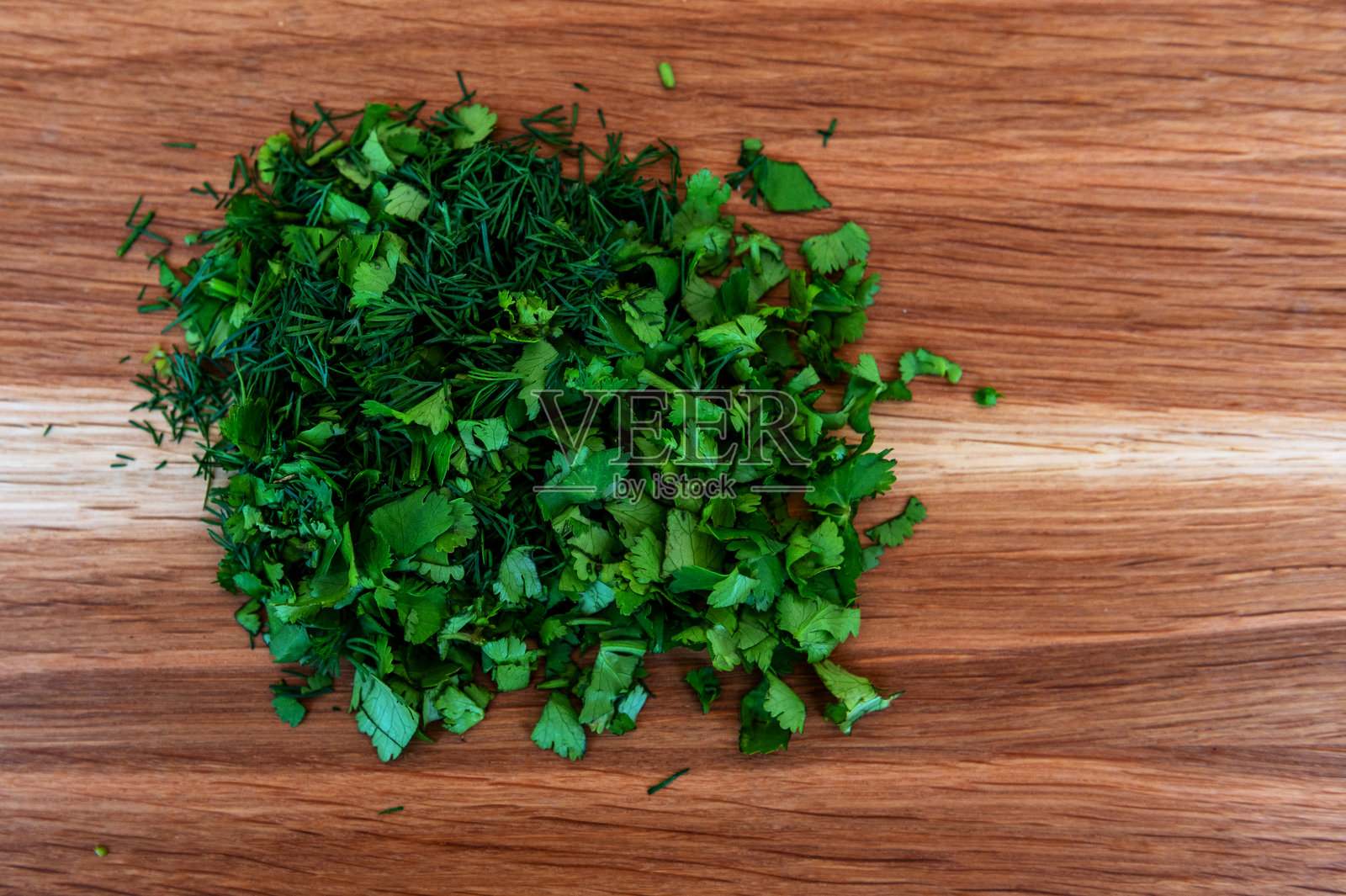 新鲜的绿色莳萝和香菜放在砧板上。食物及烹饪概念照片摄影图片