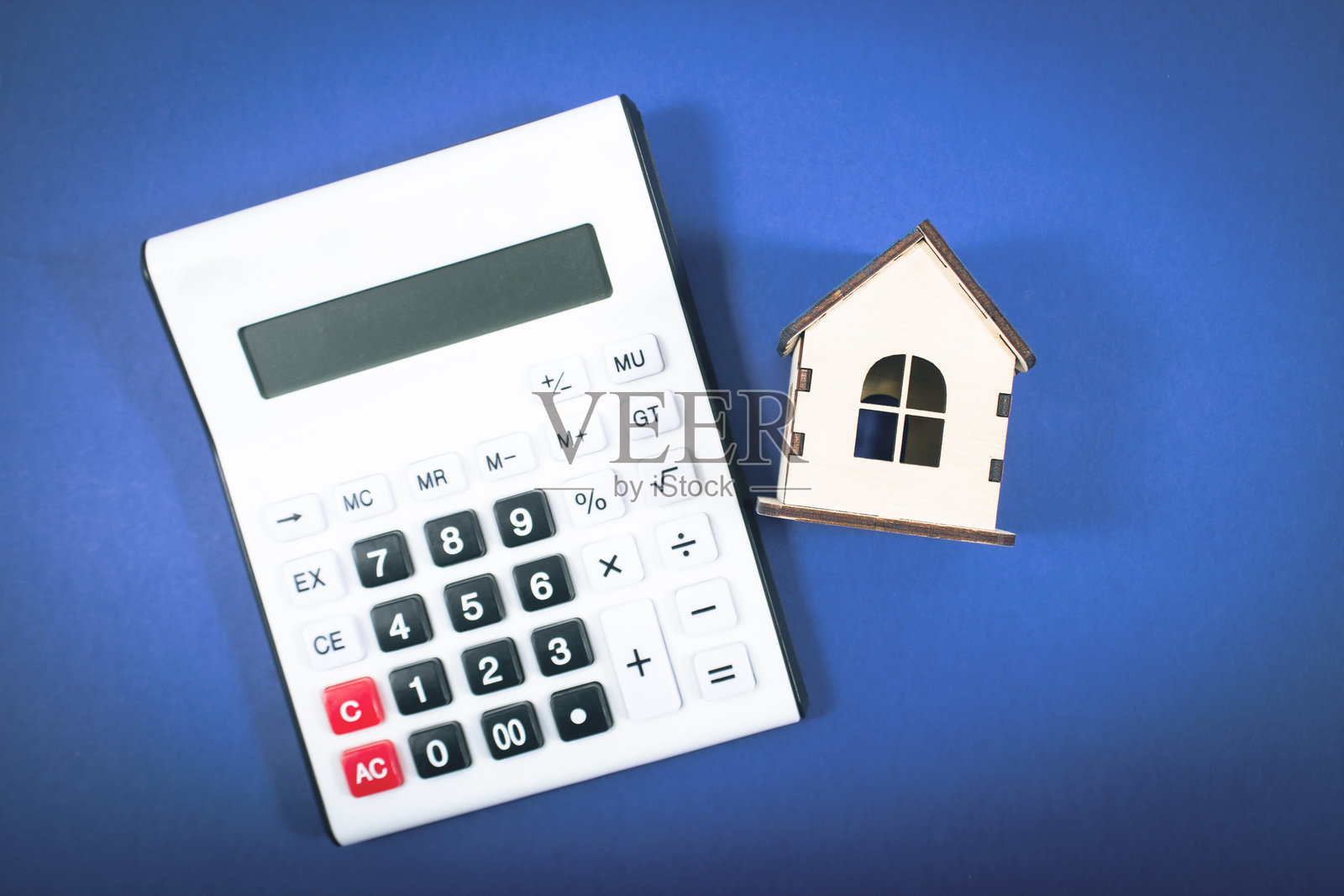 蓝色背景上的计算器和房子照片摄影图片