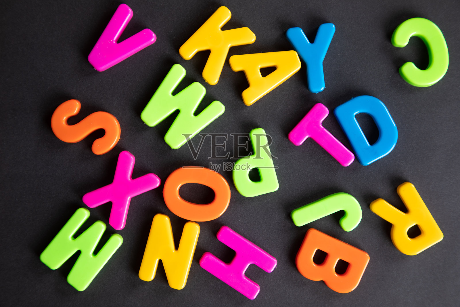 塑料字母散落在木桌上照片摄影图片