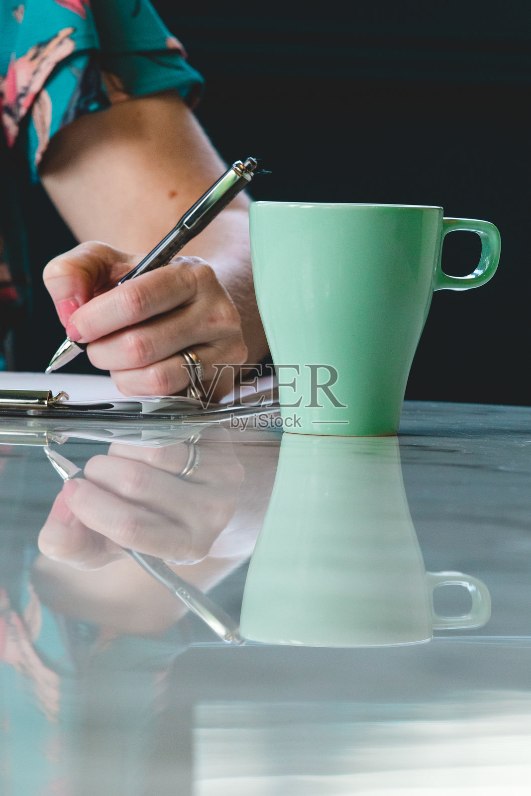 左撇子女性一边写作一边喝咖啡照片摄影图片