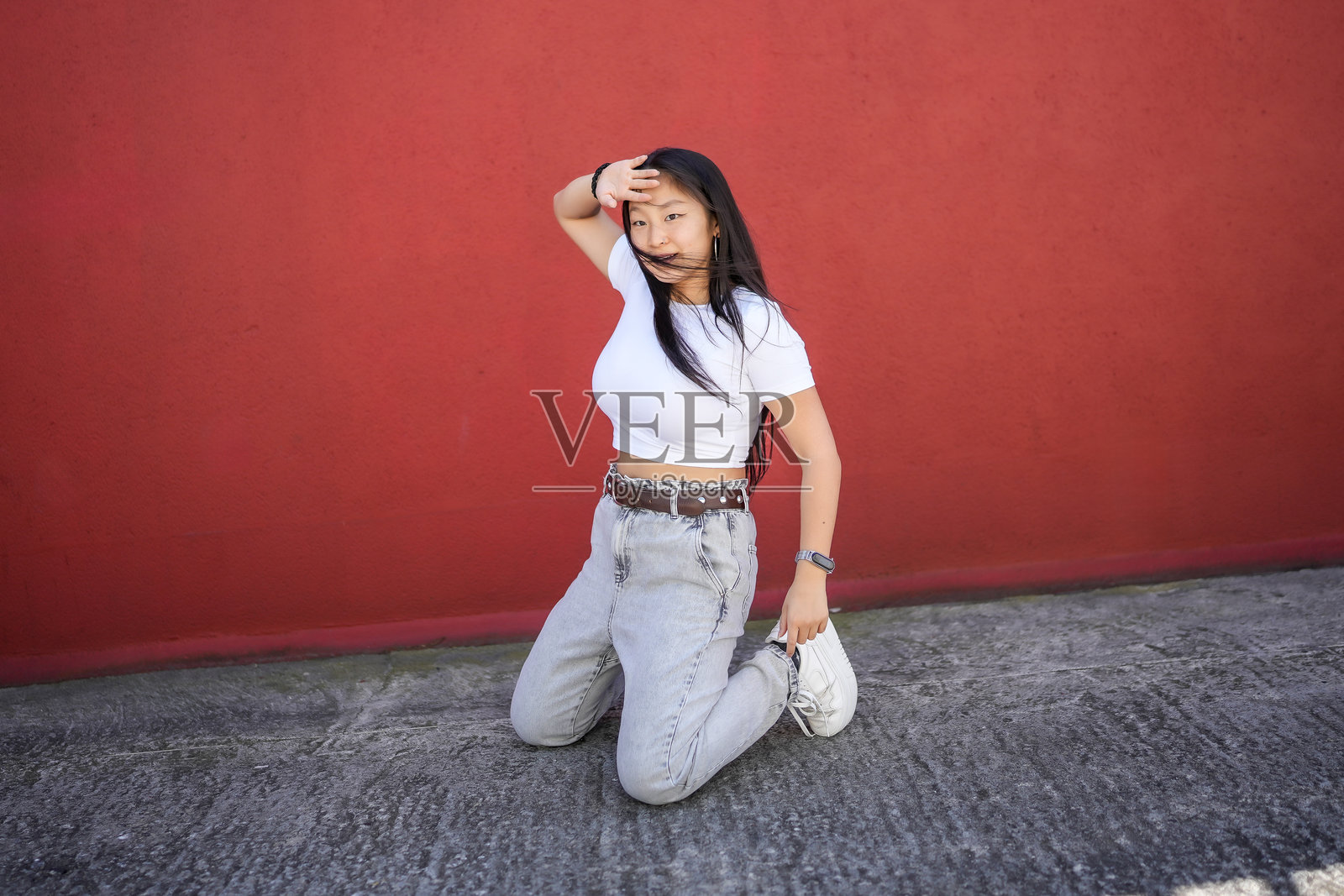 城市舞者跪着在城市中表演照片摄影图片