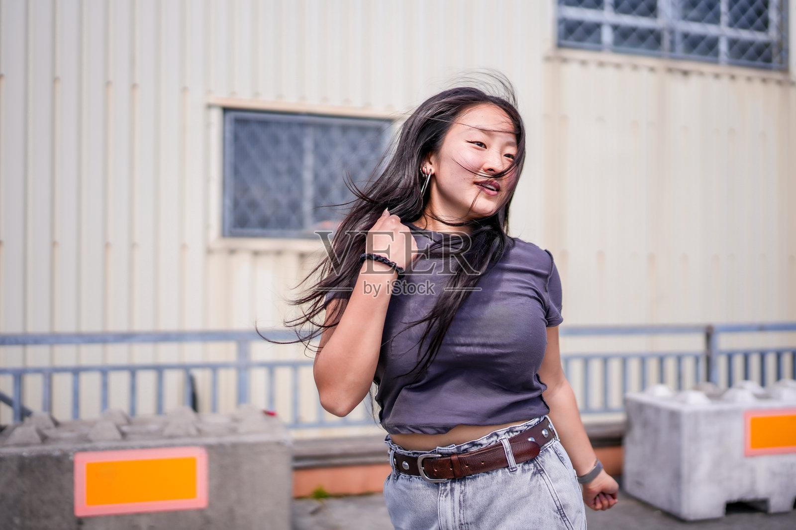 酷炫的亚洲女孩在工业建筑外跳K-pop舞蹈照片摄影图片